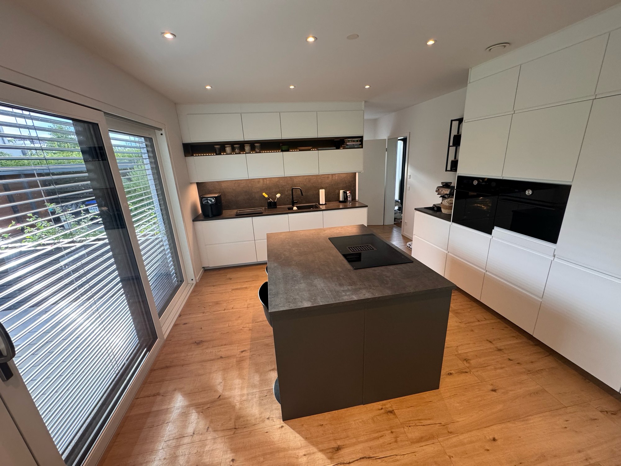 Einbauküche mit Kochinsel, Induktionskochfeld und integriertem Abzug